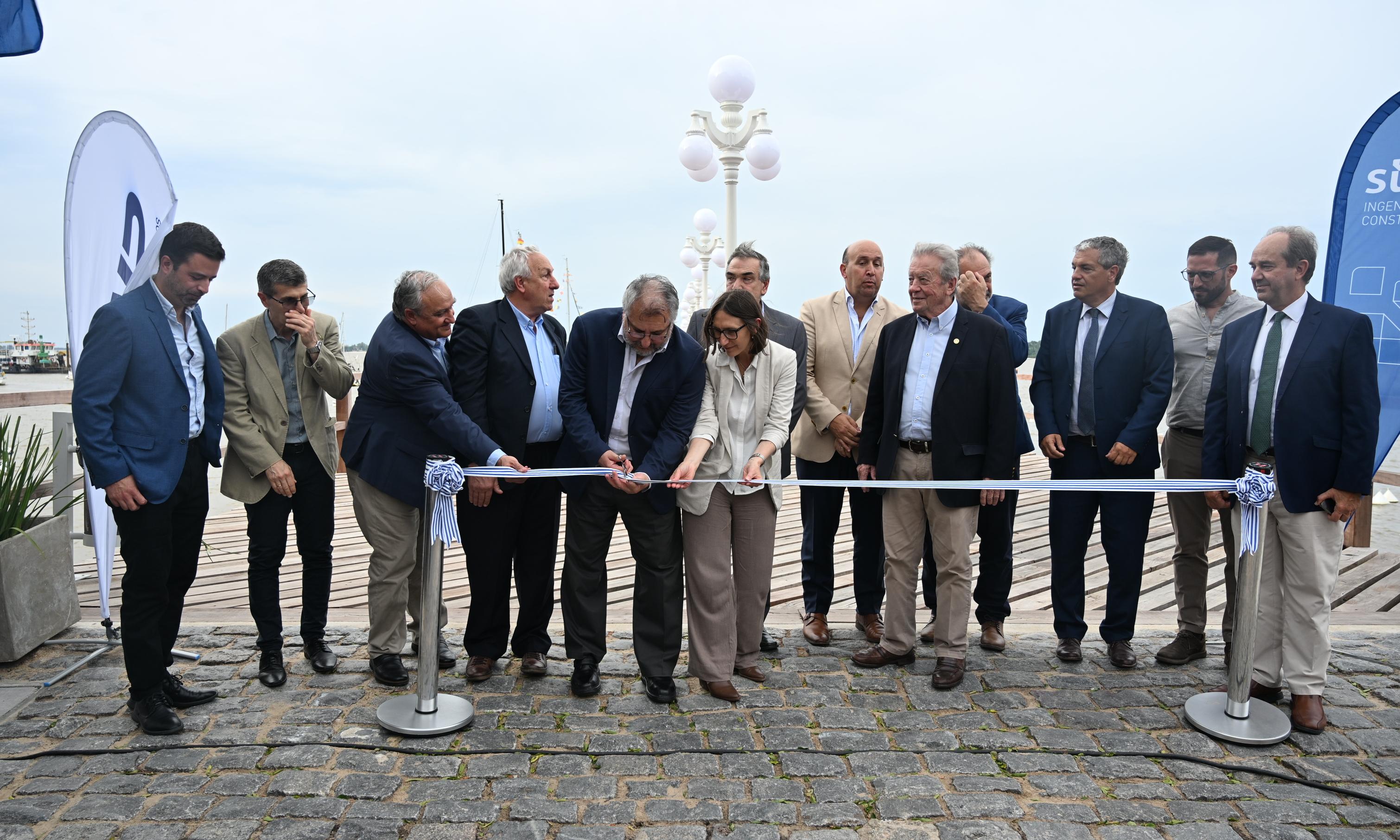 personas paradas cortando una cinta de inauguración