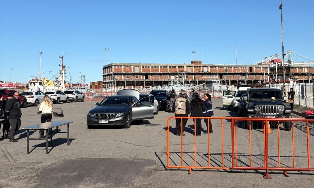 calle en un puerto de día con personas y vehículos